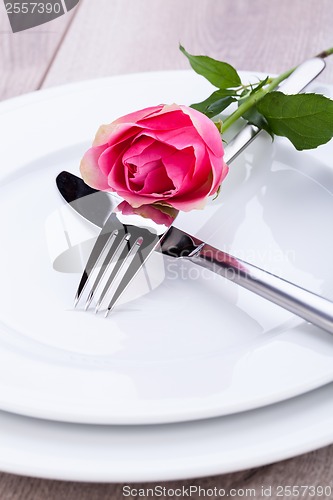 Image of Table setting with a single pink rose