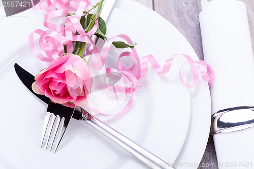 Image of Table setting with a single pink rose