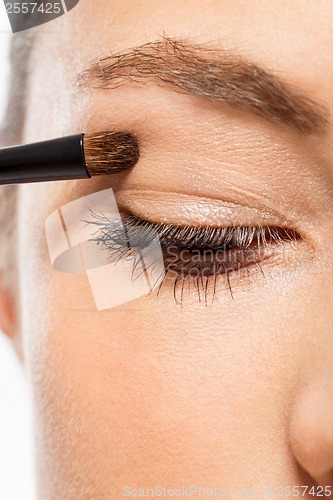 Image of doing the makeup brown eyeshadow on beautiful eyes