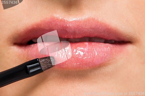 Image of woman applying lipstick on lips natural beauty