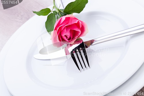 Image of Table setting with a single pink rose