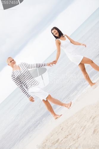 Image of Couple holding hands while walking on the beach