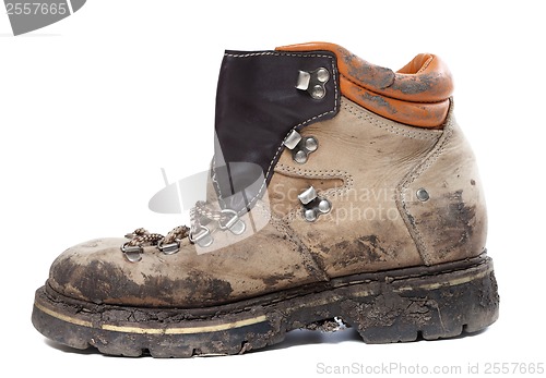 Image of Old trekking boot in mud. Side view.
