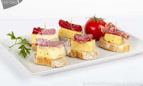 Image of thin slices of Iberian sausage omelette with bread