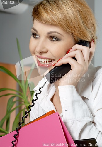 Image of office lady with folders making a phone call