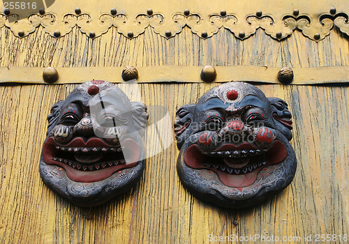 Image of Asian masks on a gold door