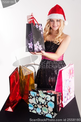 Image of Blond woman in santa hat with shopping bags