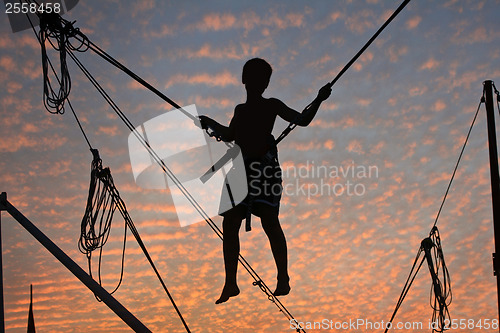 Image of Boy hanging in the air with beautiful sky in background