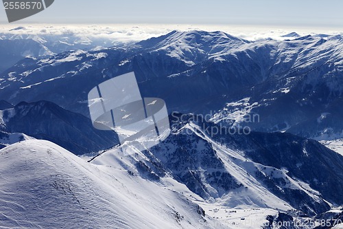 Image of Snowy mountains and off-piste slope in morning haze