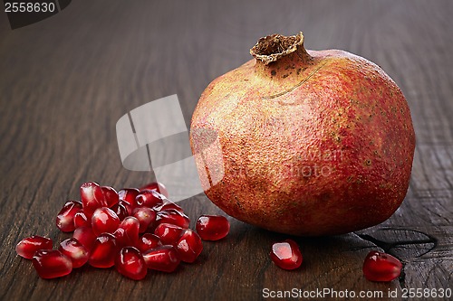 Image of Pomegranate and seeds on wooden table