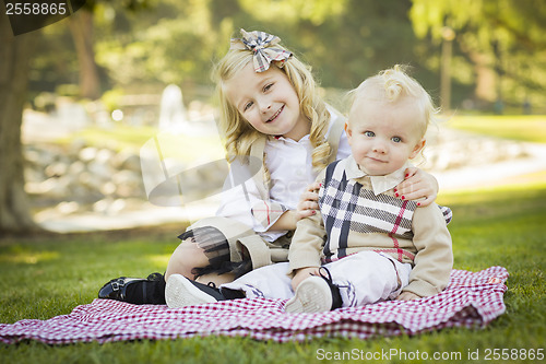 Image of Sweet Little Girl Hugs Her Baby Brother at the Park
