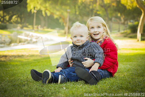 Image of Little Girl with Baby Brother Wearing Coats at the Park
