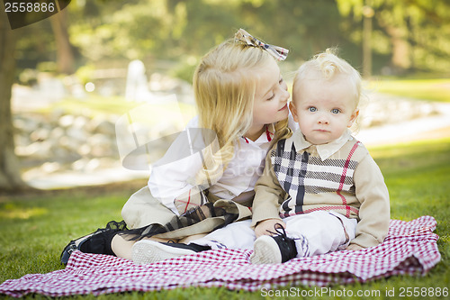 Image of Sweet Little Girl Kisses Her Baby Brother at the Park
