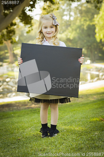 Image of Cute Little Blonde Girl Holding a Black Chalkboard Outdoors
