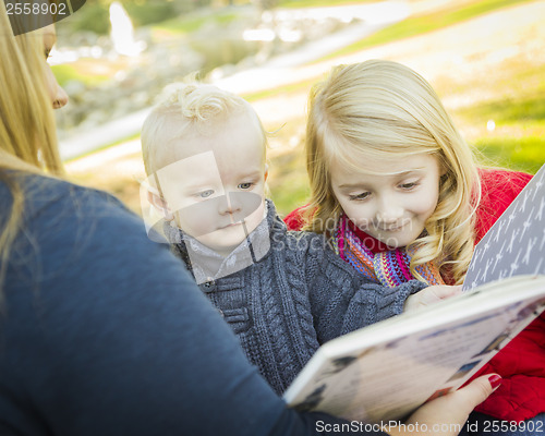 Image of Mother Reading a Book to Her Two Adorable Blonde Children
