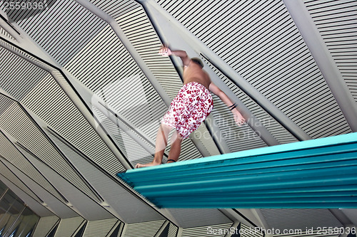 Image of Boy jumpimg at the pool