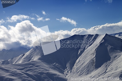 Image of Off piste slope in evening with sunlit clouds