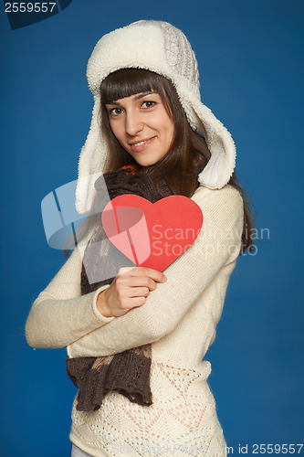 Image of Winter woman in warm clothing giving heart shape