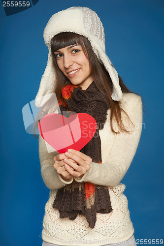 Image of Winter woman in warm clothing giving heart shape