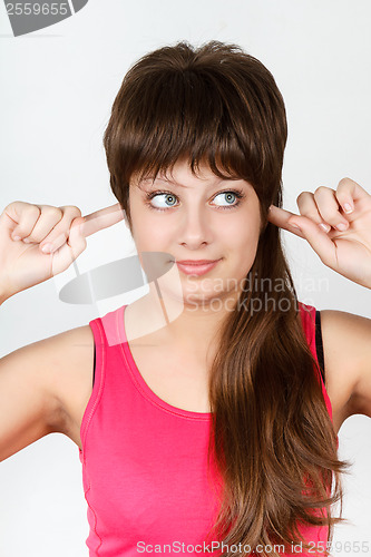 Image of Young attractive girl covers her ears