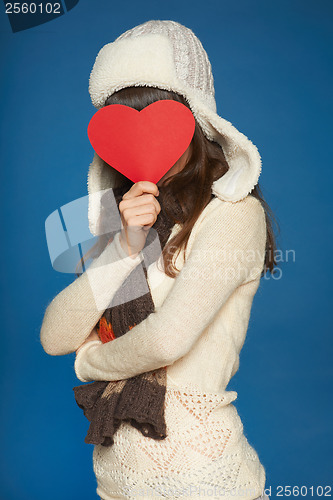 Image of Winter girl holding heart shape in front of face
