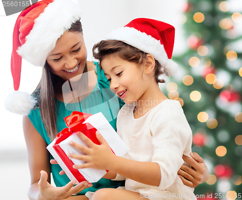 Image of happy mother and child girl with gift box