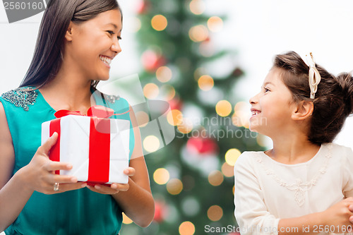 Image of happy mother and child girl with gift box