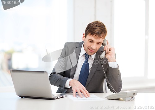 Image of businessman with laptop computer and phone