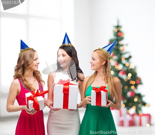 Image of three smiling women in blue hats with gift boxes