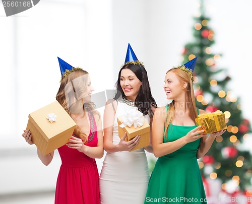 Image of three smiling women in blue hats with gift boxes