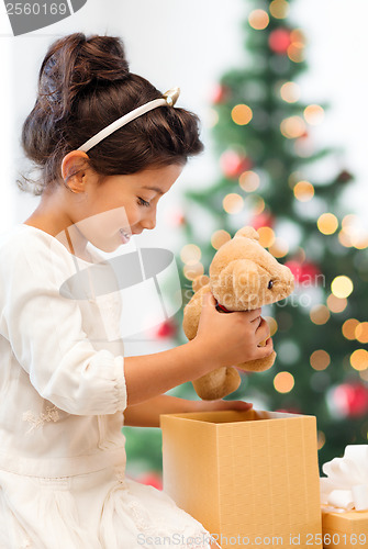 Image of happy child girl with gift box and teddy bear