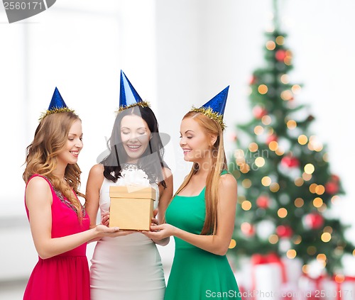 Image of three smiling women in blue hats with gift box