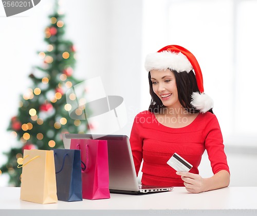 Image of woman with shopping bags, laptop and credit card