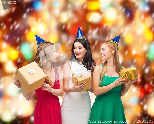 Image of three smiling women in blue hats with gift boxes