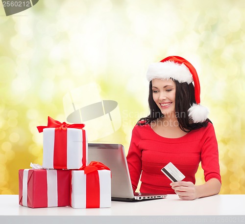 Image of woman with gifts, laptop computer and credit card