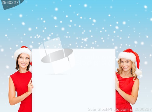 Image of women in santa helper hats with blank white board