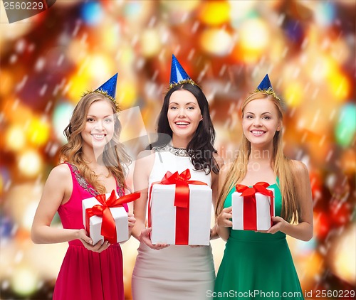 Image of three smiling women in blue hats with gift boxes