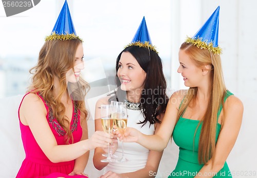 Image of three women wearing hats with champagne glasses