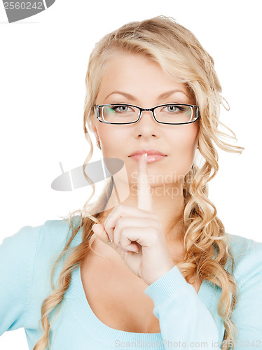 Image of woman wearing eyeglasses with finger on her lips