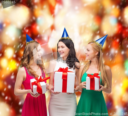 Image of three smiling women in blue hats with gift boxes
