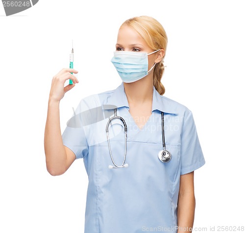 Image of female doctor or nurse in mask holding syringe