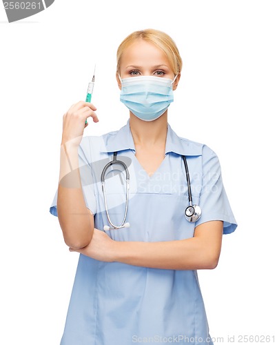 Image of female doctor or nurse in mask holding syringe