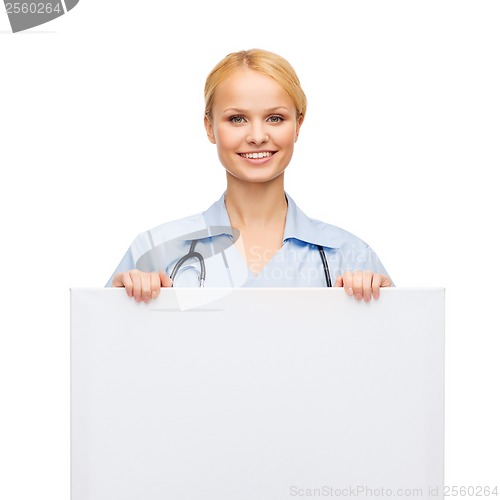 Image of smiling female doctor or nurse with blank board