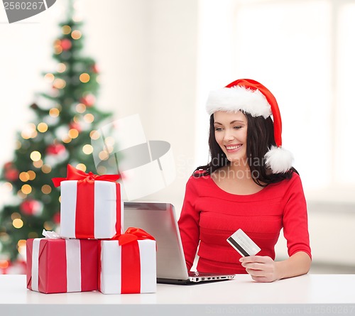 Image of woman with gifts, laptop computer and credit card