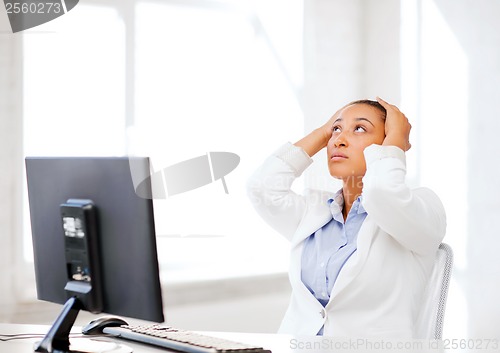 Image of stressed african woman with computer