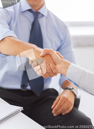 Image of businessmen shaking hands in office