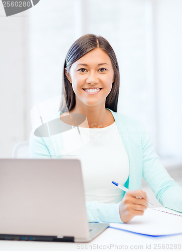 Image of asian businesswoman with laptop and documents