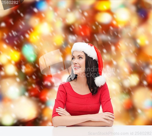Image of surprised woman in santa helper hat looking up