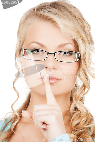 Image of woman wearing eyeglasses with finger on her lips