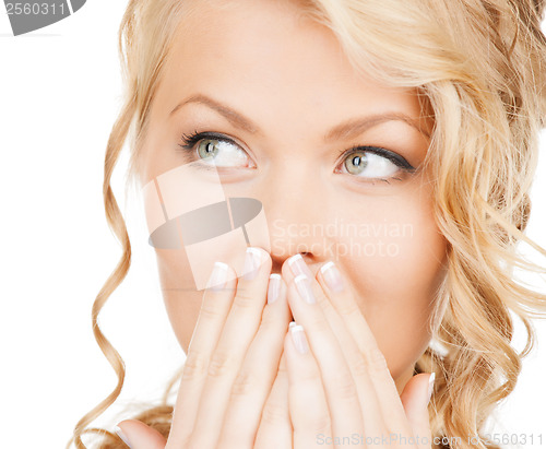 Image of face of beautiful woman covering her mouth